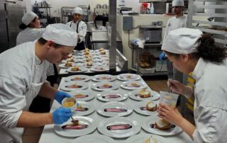 Students work in tandem to plate dessert.